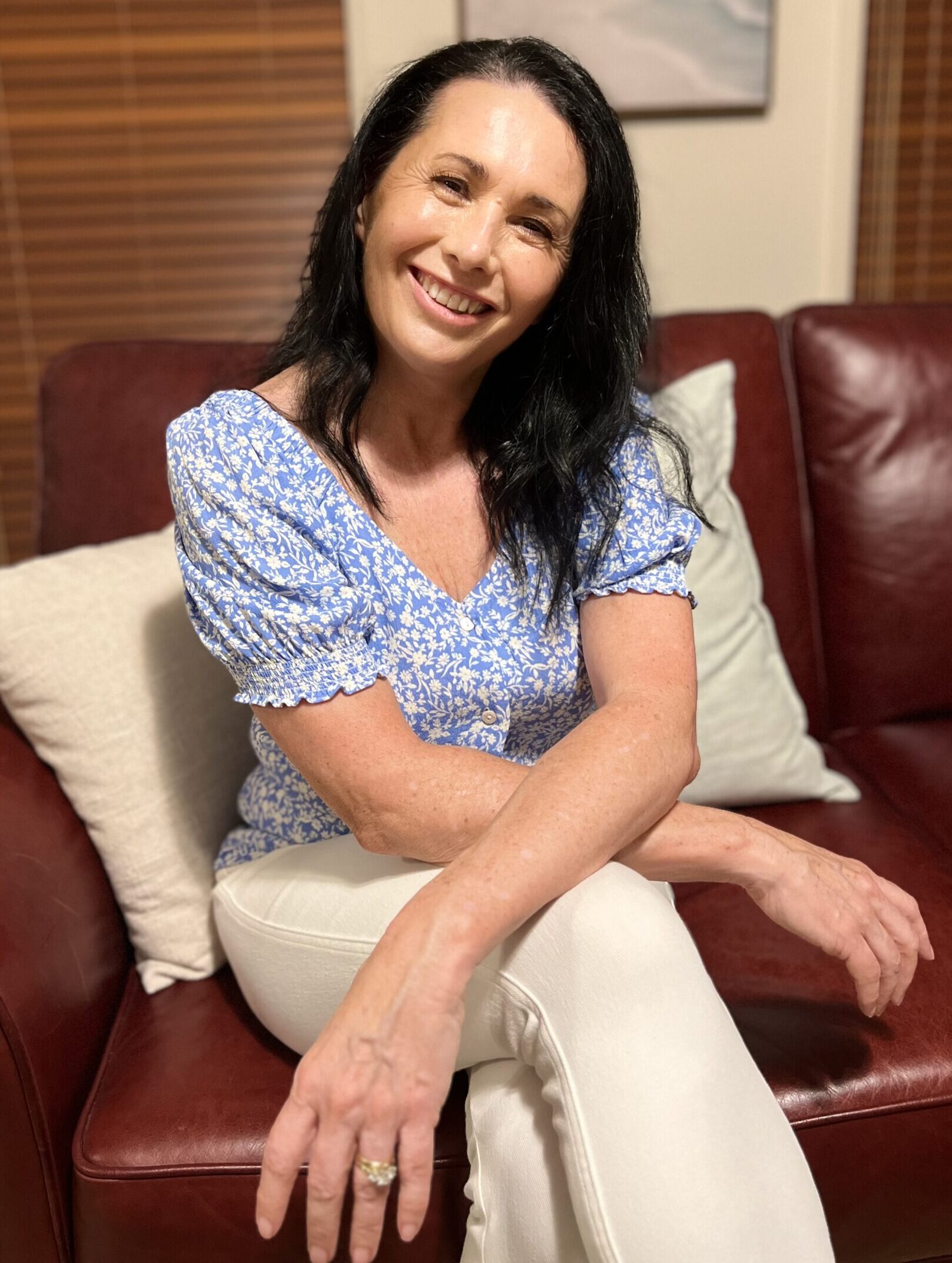 Portrait of Amanda Hefez smiling, the author of 'The In Sync Method', seated in a cozy office setting, symbolizing a warm and welcoming approach to psychological well-being and personal growth